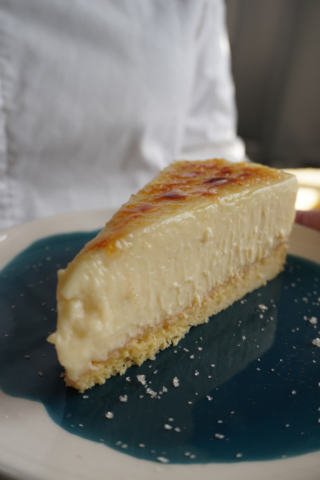 Fatia de torta de cafeteria com creme e calda azul decorada com açúcar cristalizado